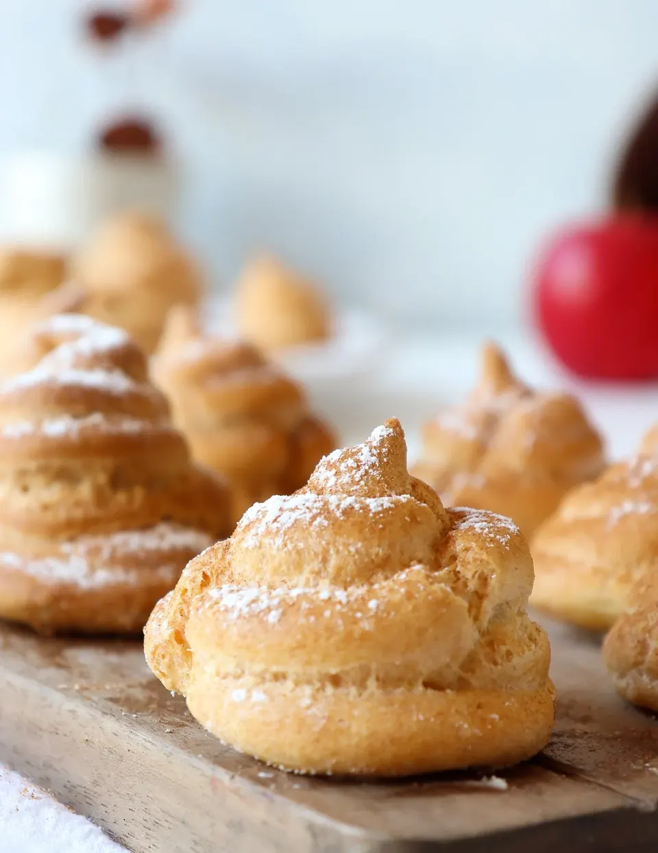 Powdered sugar dusted profiteroles on a wooden board